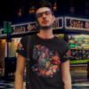 Hipster in front of a bodega wearing a chinese art tshirt depicting a tattooed horse with decorated neckline and sleeves, at night.
